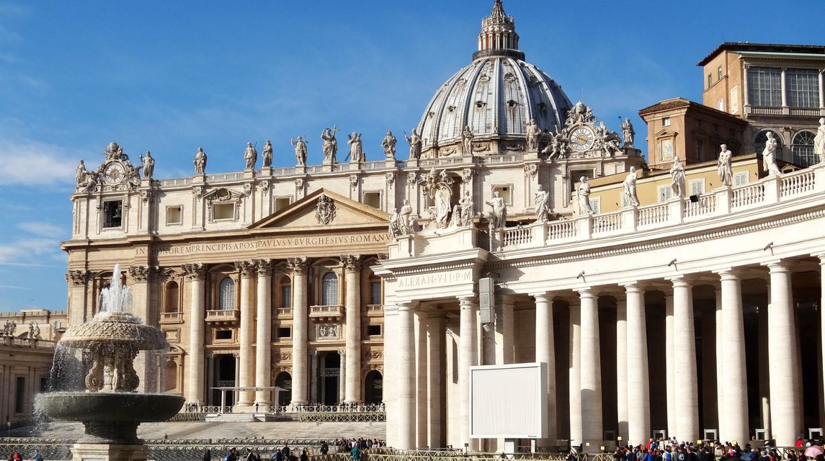 St. Peter's Basilica and its dome seen across St. Peter's Square, with the colonnade and a fountain in the foreground