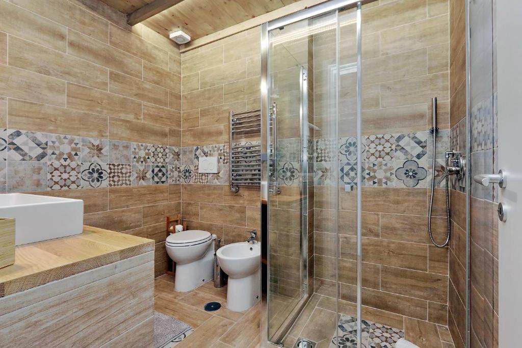 Bathroom clad in warm wood-effect tile with glass shower