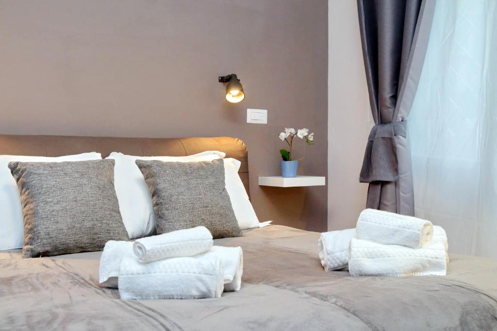 Double bed with folded towels beside a curtained window